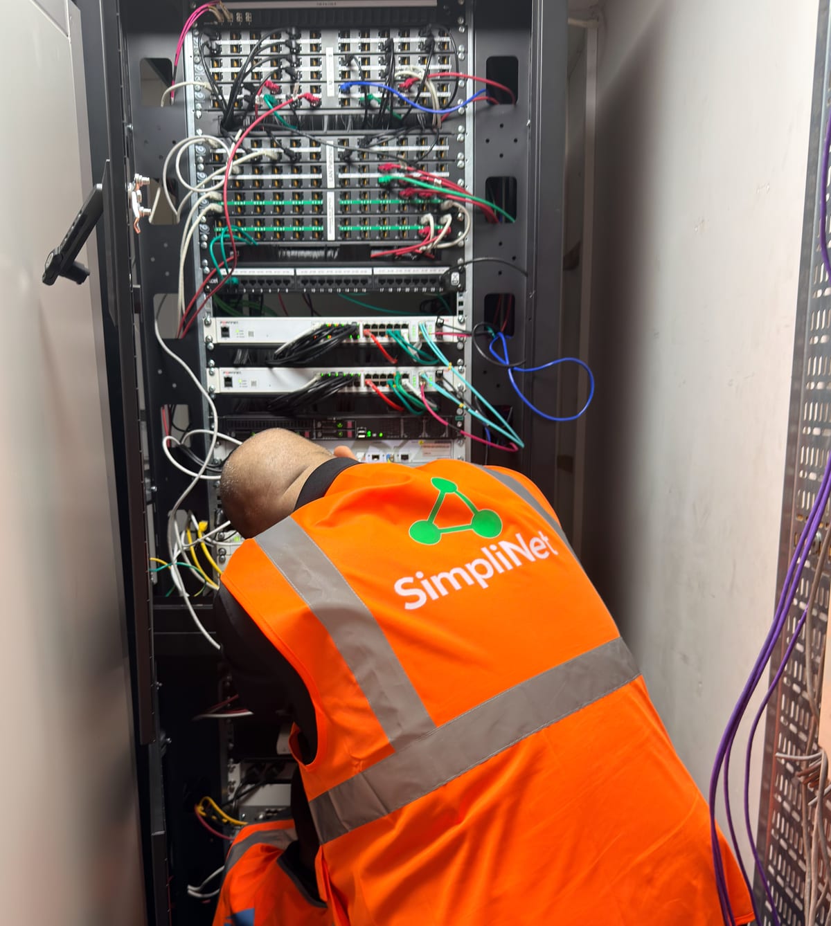 A Simplinet engineer at work in a comms room